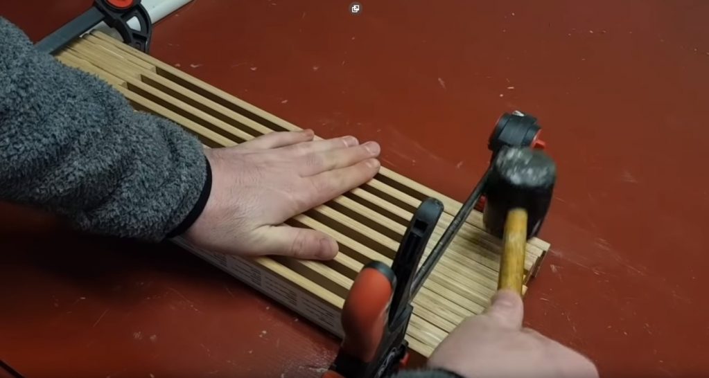 Выравнивание досок, из которых набрана подставка при помощи киянки