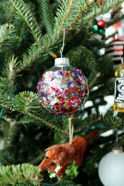 Блеска много не бывает. Рождественский шар, оклеенный блестящим конфетти красиво мерцает в елочных огнях. Для его изготовления понадобиться только клей ПВА и россыпь конфетти