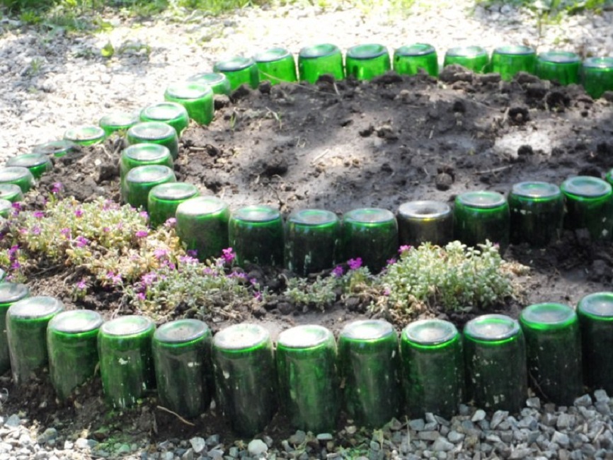 Бордюр клумбы из стеклянных бутылок зелёного цвета