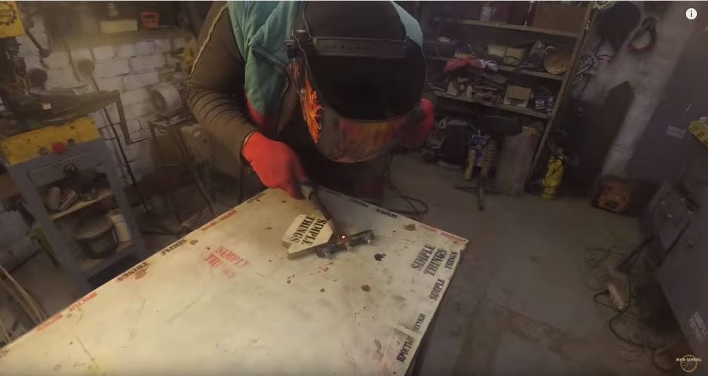 С обратной стороны трубы на сквозное отверстие привариваем длинный кусок ручки